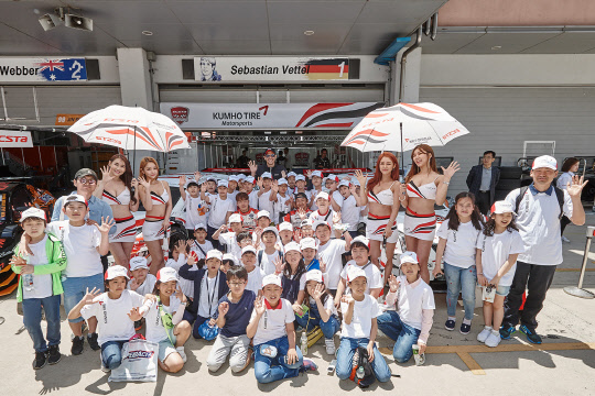 14일 전라남도 영암 코리아 인터내셔널 서킷에서 열린 금호타이어의 모터스포츠 교육 기부 프로그램에참가한 광주 살레시오 초등학교 학생들이 기념촬영을 하며 환한 미소를 짓고 있다.   금호타이어 제공